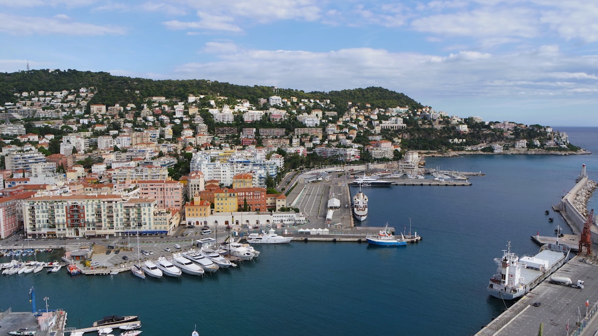 Yacht cruising along the French Riviera coastline during golden hour