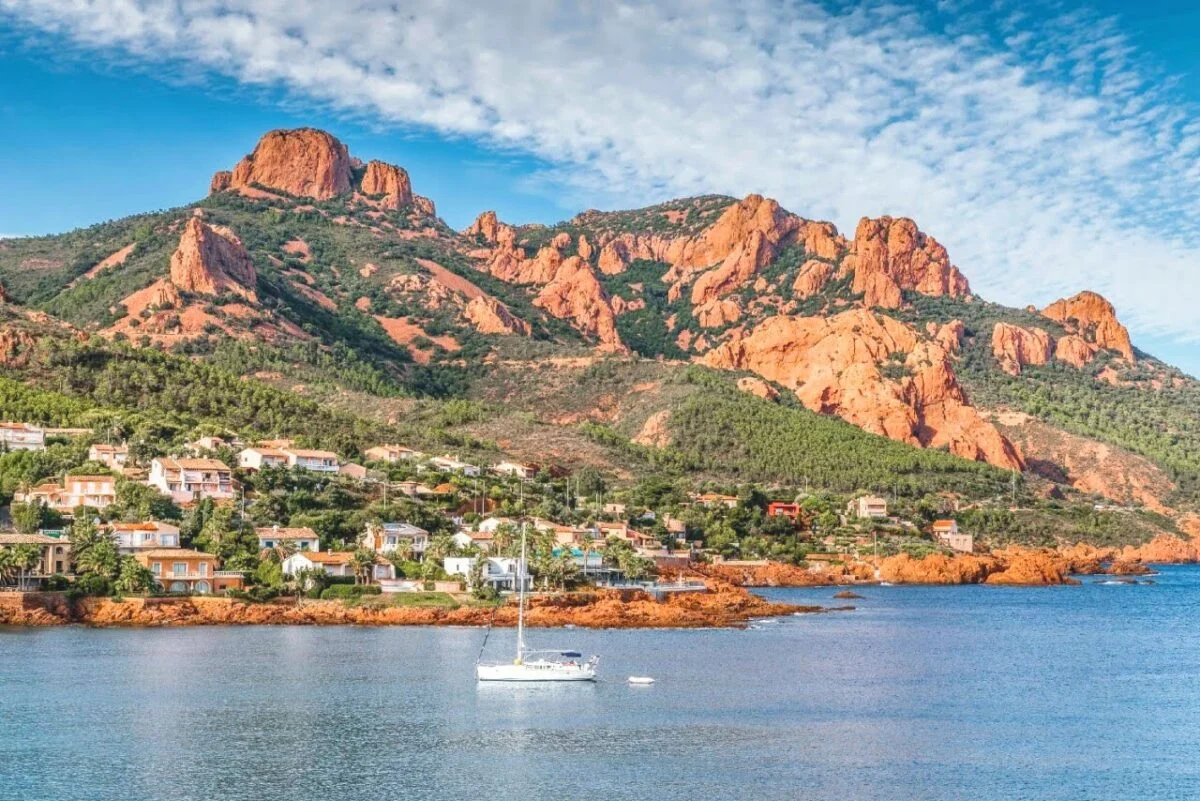 Red volcanic rocks of the Esterel coast meeting turquoise Mediterranean water near Cannes
