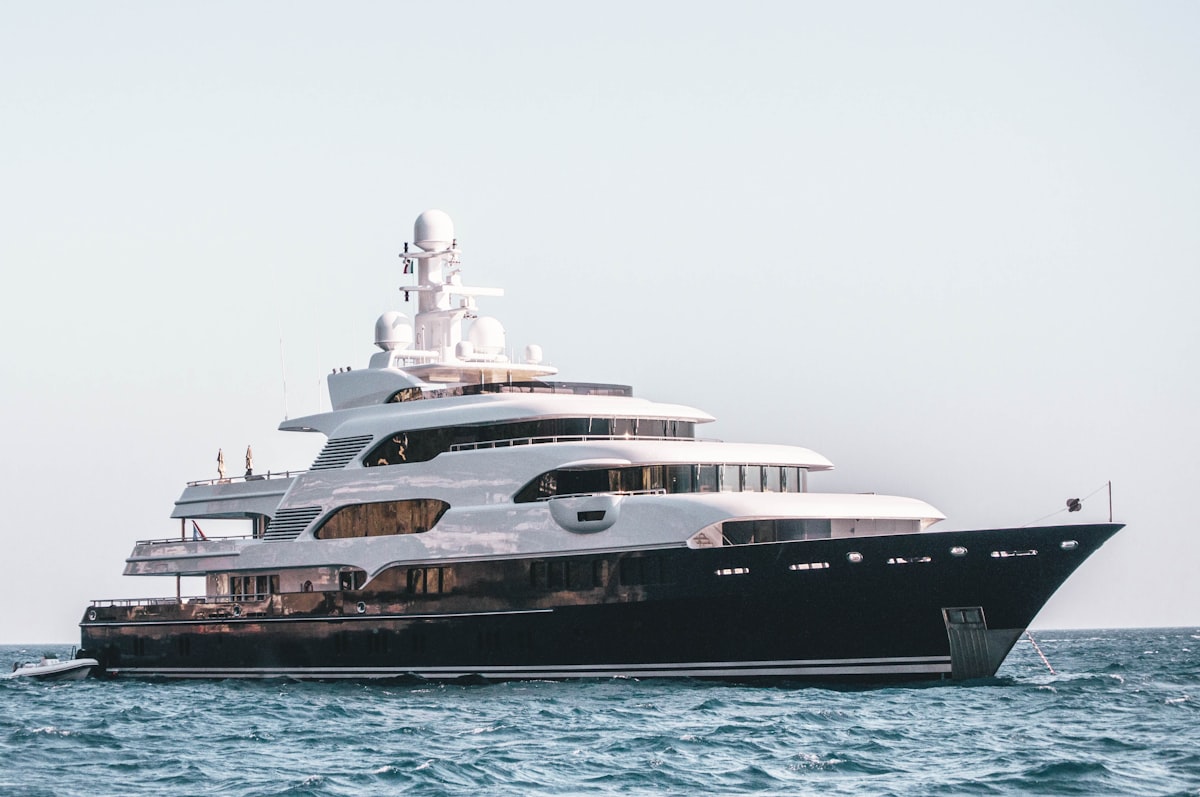 Superyacht cruising through a dramatic Norwegian fjord under the midnight sun