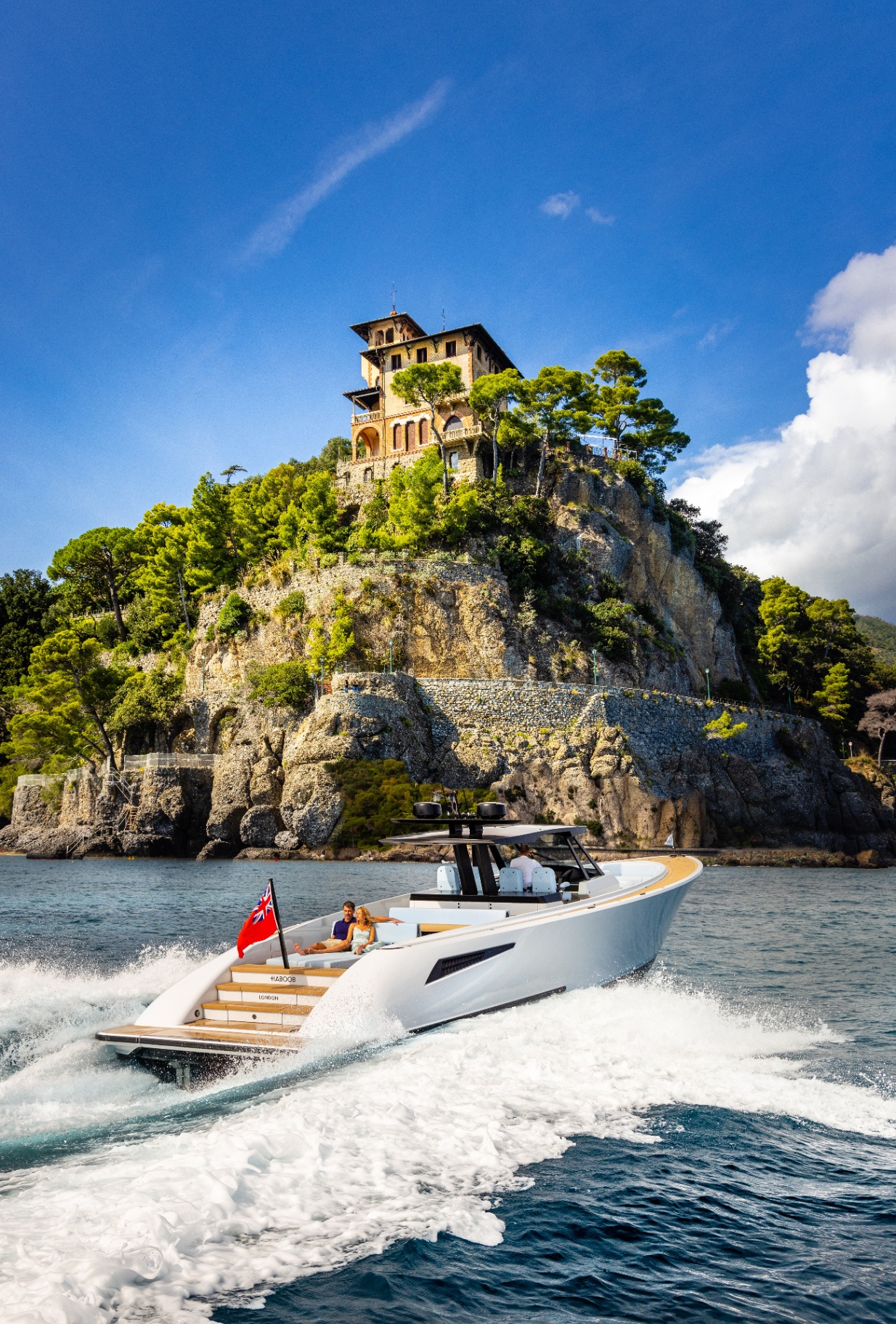 Luxury motor yacht cruising at speed along the French Riviera coastline