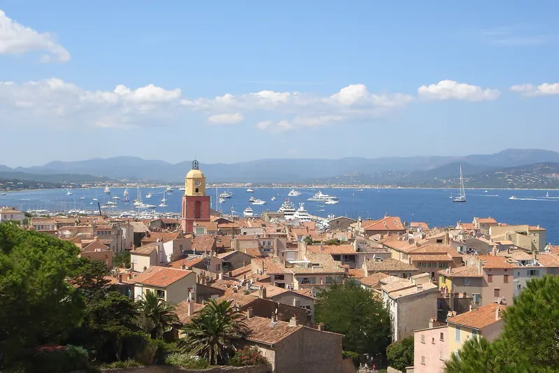 The rooftops and bell tower of Saint-Tropez with yachts anchored in the gulf