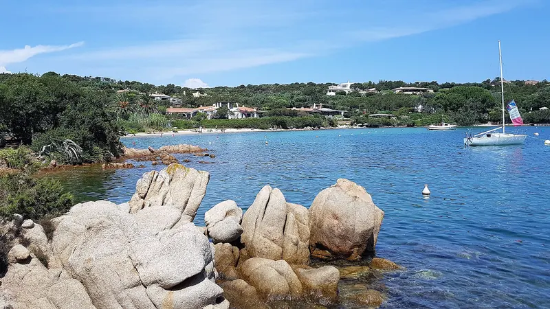 Granite rocks and a sailing yacht at anchor near Porto Cervo on the Costa Smeralda, Sardinia